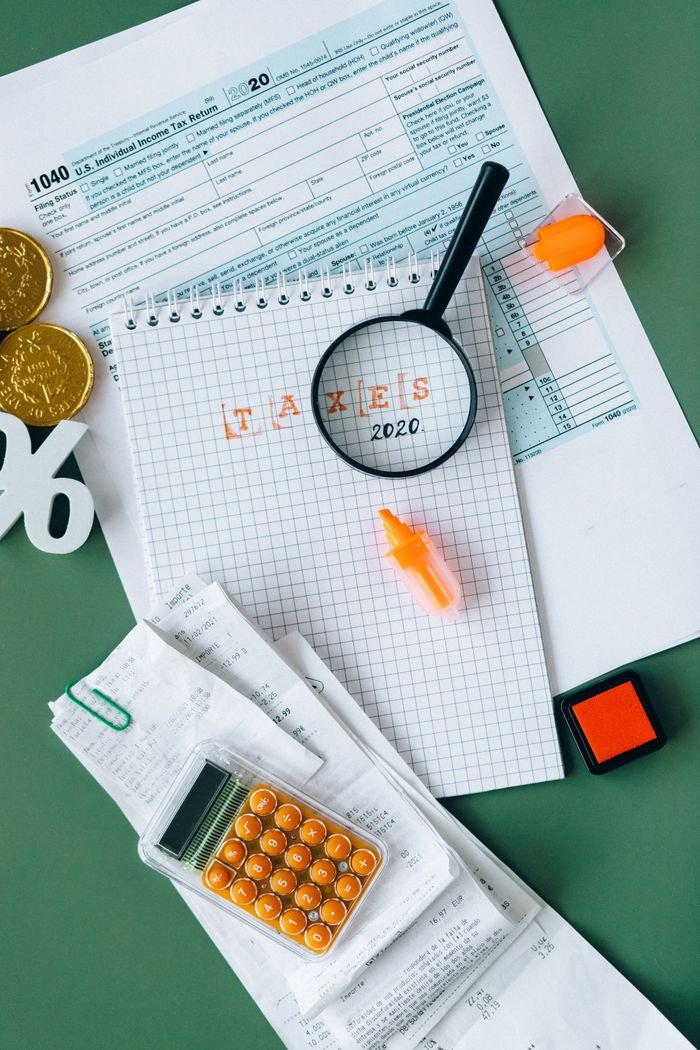 Offerings Top view of tax documents, calculator, and office supplies showcasing finance and accounting concepts.